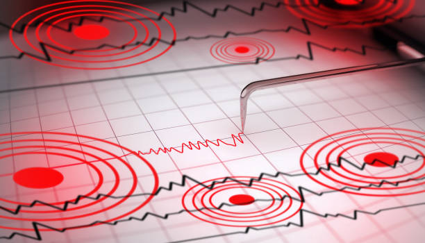 Seismic Waves Analysis Close-up of a seismograph machine needle tracing seismic waves, indicative of earthquake activity, on graph paper with epicenter rings. seismograph stock pictures, royalty-free photos & images