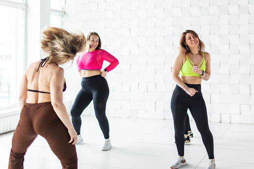 Small group of women dancing zumba in exercise room