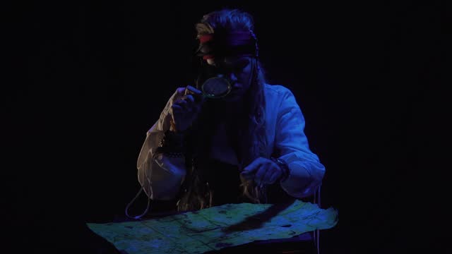 Female pirate is sitting in front of the map with a magnifier at night, 4k