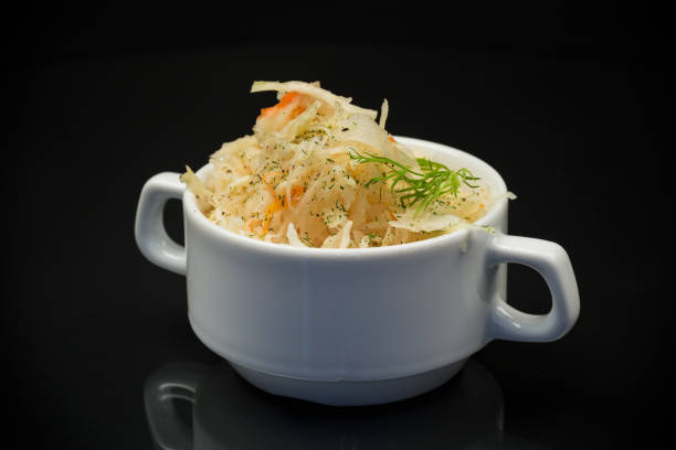 sauerkraut with carrots and spices in a white bowl stock photo