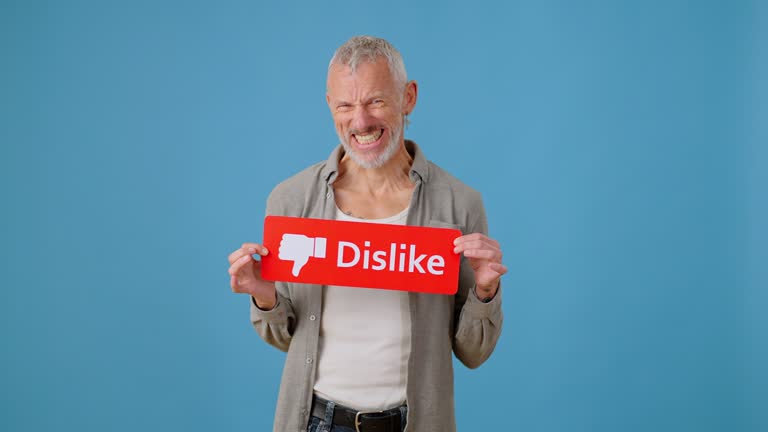 Mature man shows red Dislike button with thumbs down