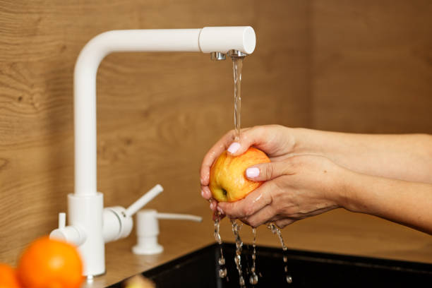 istock Washing an Apple Under Tap Water 2007557600