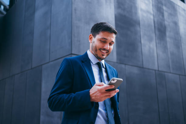 istock Handsome Businessman Reading a Text Message While Walking on the Street 2007576213