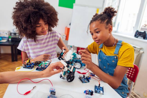 Children students building robotic cars at STEM classv