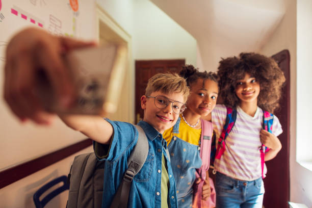 istock A group of elementary school students at the school lobby using smartphone 2007593886