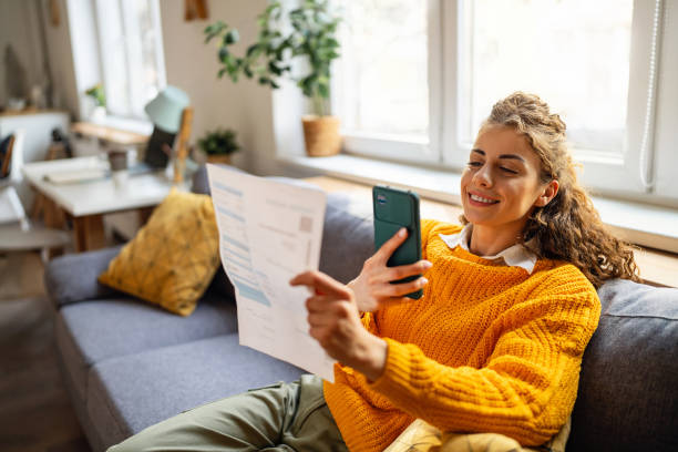 istock Young woman using mobile phone to scan the QR code and paying the bill 2007594396