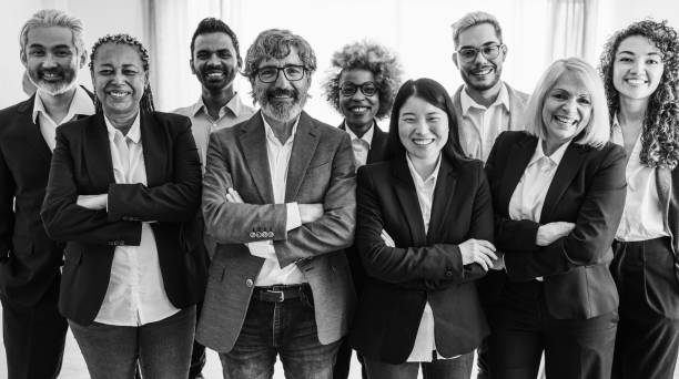 istock Multi generational workers smiling in front of camera inside business office - Multiracial entrepreneur and teamwork concept - Main focus on man with glasses - lack and white editing 2007594706