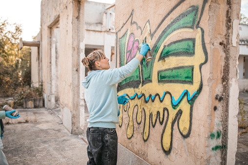Young woman standing in front of the graffiti on the wall