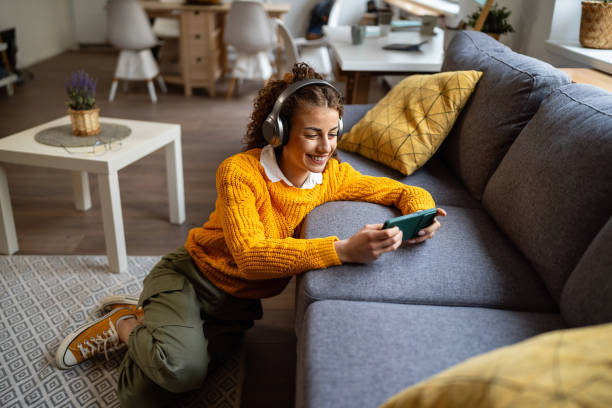istock Young woman playing video games on mobile phone 2007595250