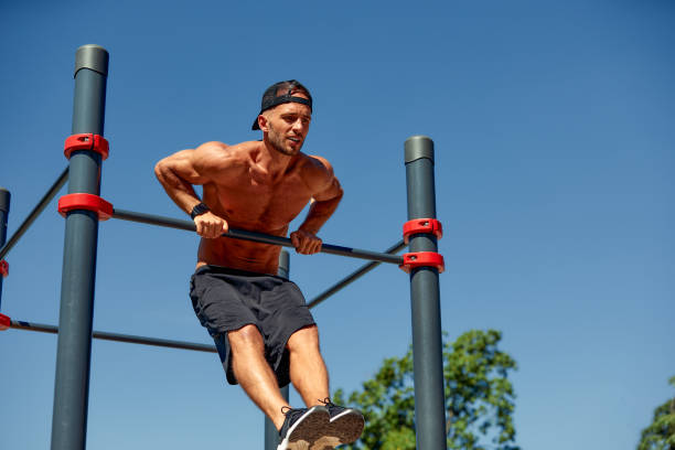 istock Athletic young man hanging from the bars at the calisthenics gym outdoors smiling 2007602425