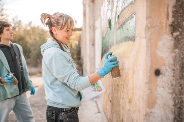 istock Side view of two cheerful street artists drawing graffiti 2007623613