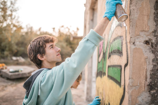istock Side view of two smiling street artists drawing graffiti 2007630490