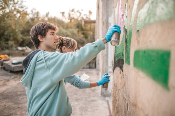istock Side view of two talented street artists drawing graffiti with sprays 2007636964