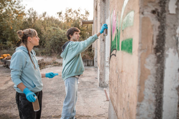 istock Side view of two young street artists drawing graffiti with sprays 2007638923