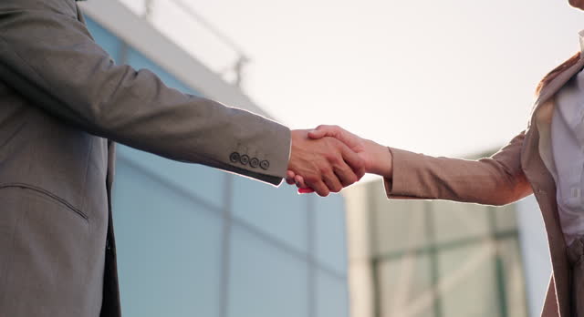 Business people, handshake and hello for recruitment in outdoors, partnership and deal in city. Coworkers, lens flare and promotion or agreement and networking, closeup and support in onboarding