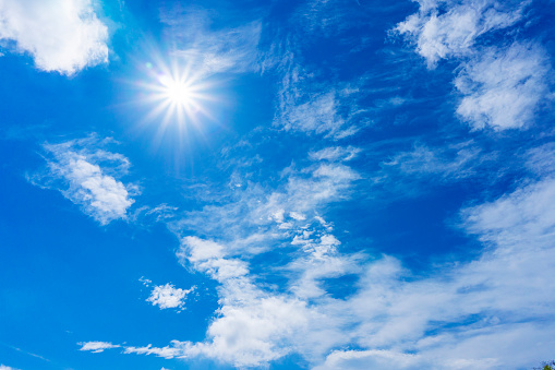 Background material of sun flare and refreshing blue sky and clouds\nThe flare of the sun and the refreshing blue sky