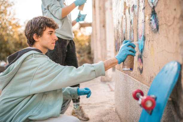 istock Two friends draw graffiti. The man uses blue spray paint 2007656399