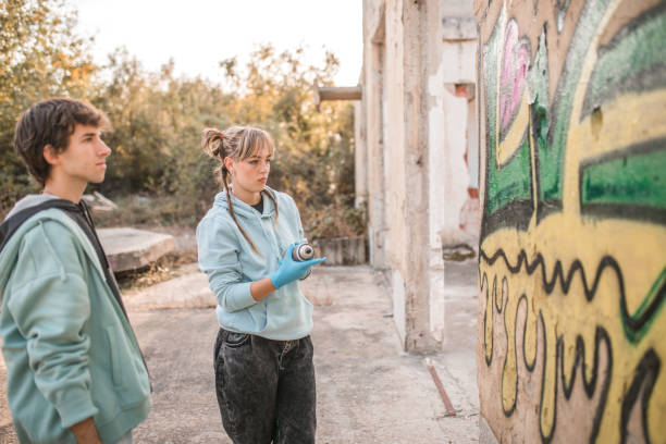 istock Two talented friends draw graffiti on the wall of an abandoned building 2007667398