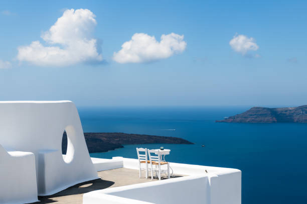 White architecture in Santorini island, Greece. Two chairs on the terrace with sea view. stock photo