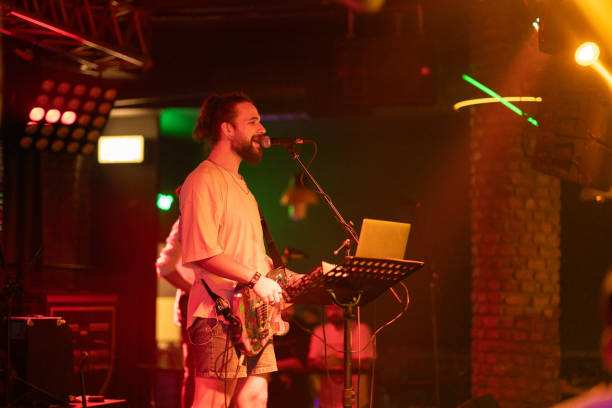 istock Young man singing and playing bass on a show 2007688070