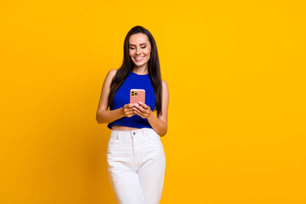 istock Photo of sweet shiny lady dressed blue top communicating modern device empty space isolated yellow color background 2007704889