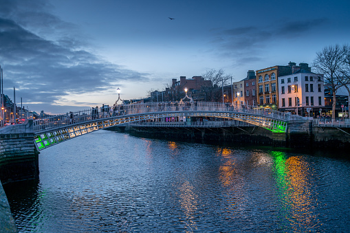 Dublin, Ireland - 12/26/2016: Ha'penny Bridge Dublin at dusk over the river Liffey