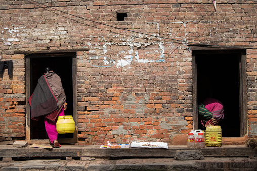 Kathmandu, Nepal- April 20,2023 : Women wash clothes and dishes on the streets of Patan Durbar Square.
