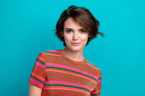 Photo of good mood gorgeous woman with short hairstyle dressed striped t-shirt staring at camera isolated on turquoise color background.