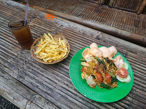 Delicious Instant Fried Noodles Or Mie Goreng Instan With French Fries And Fresh Tea Iced. Mi Goreng Instan Dengan Kentang Goreng Dan Minuman Es Teh Segar. Food And Drink Menu.