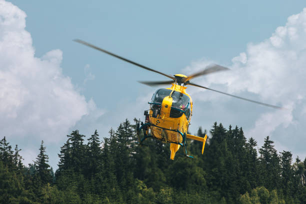 red rescue helicopter landing on airfield in valley in Bernese Oberland Switzerland.