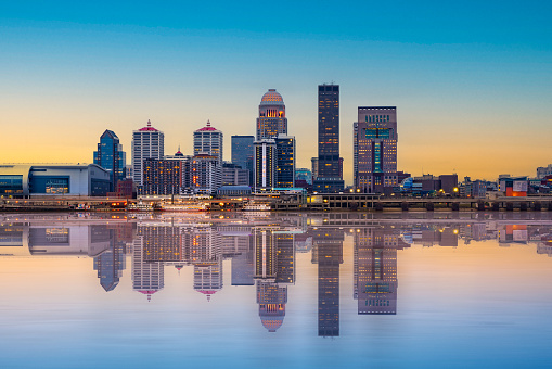 Beautiful sunset night view of Louisville Kentucky Skyline with river and lit buildings