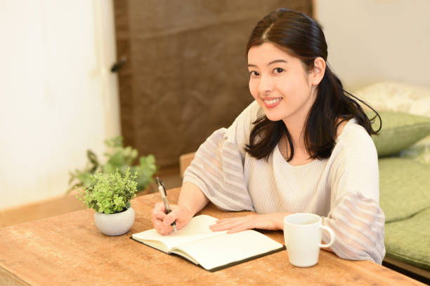 istock Young beautiful Asian woman studying at home and taking notes 2007820102