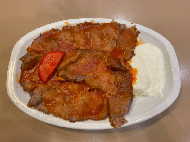 istock Traditional turkish iskender kebab on white plate with yogurt, tomatoes and melted butter 2007849621