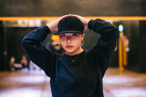 Portrait of a stylish young Japanese woman in a hip hop dance studio.