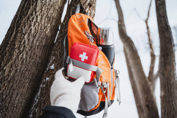 istock First aid kit on an orange backpack near the tree in the snowy forest. 2007859288