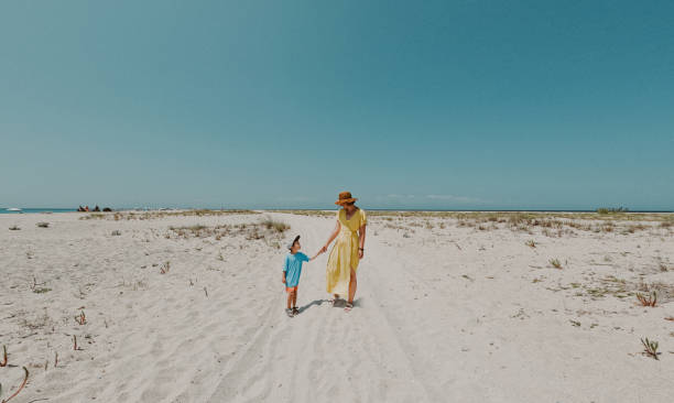 istock Mother and son are walking down the beach 2007883431