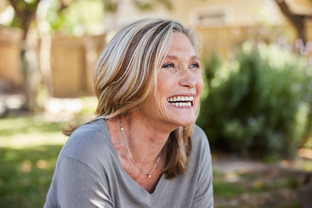 istock Mature woman laughing while sitting outside in her back yard 2007889947