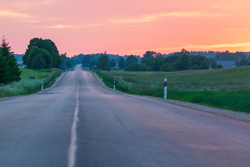 Beautiful rural asphalt road scenery at sunset or sunrise.Asphalt Road between fields trees.beautiful summer landscape with road sunset.