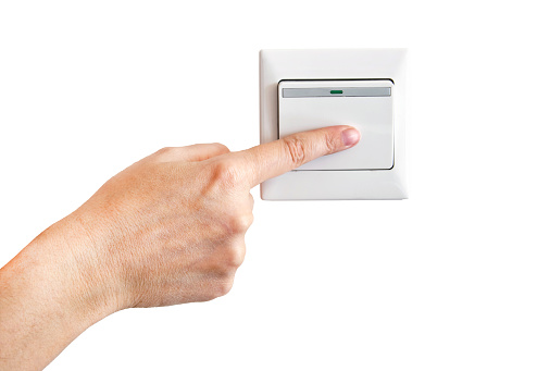 Hand with finger on light switch isolated on white background