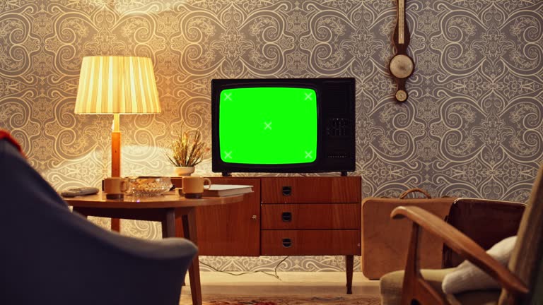 DS An old TV set on the cupboard in the living room with a green screen