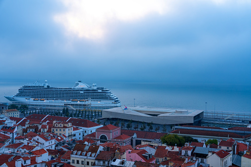 Lisbon, Portugal - Oct. 2, 2023: A cruise ship is waiting for tourists at the pier. Alfama Lisbon Cityscape at dawn, Portugal.