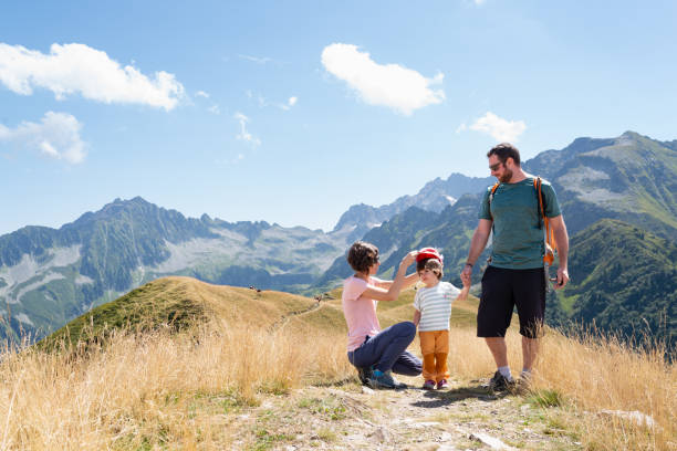 istock Little daughter holding her father hand while her mother is putting a cap on her during a hiking day in Le Collet d'Allevard, French Alps. 2007967939