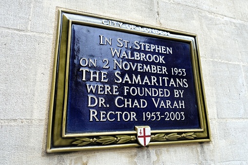 London, England, UK - February 10th 2024: Blue plaque marking where Dr Chad Varah founded the Samaritans in 1953 on the exterior wall of St. Stephen Walbrook Church in the City of London.