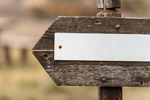 Close-up picture of a weathered wooden arrow directional sign