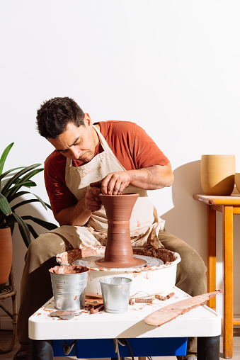 Male artisan shaping clay in professional pottery