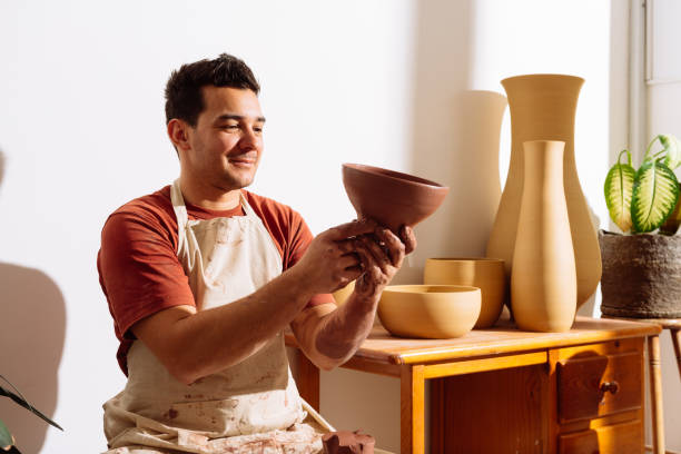 istock Cheerful male potter making clay bowl in pottery workshop 2008036086