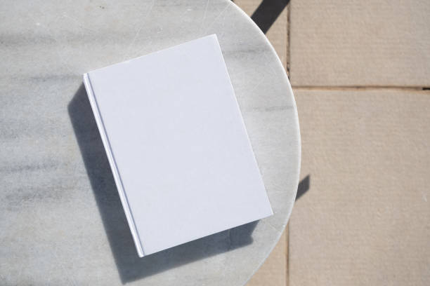 istock blank book for mockup design on marble table by the swimming pool 2008058713