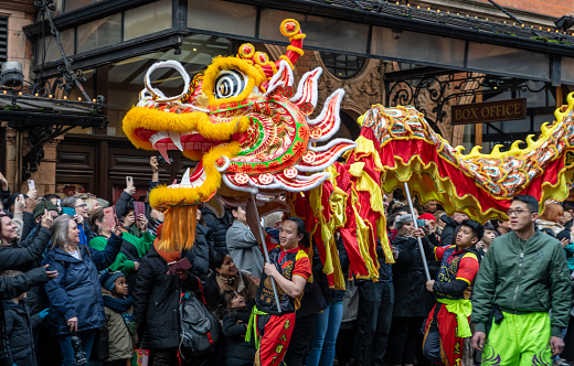 London. UK- 02.11.2024.  Close up of a group performing a dragon dance in the Chinese New Year celebration parade with a large appreciative crowd.