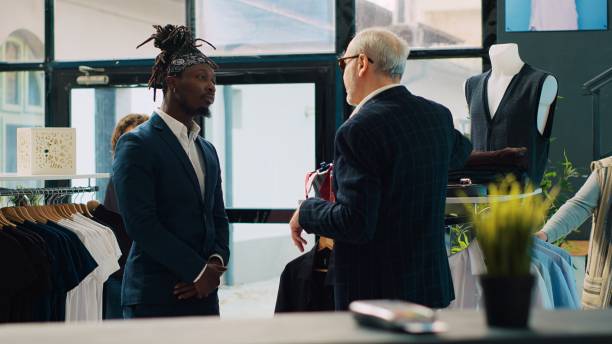 istock Senior designer teaching his apprentice to match ties on elegant suits 2008096072