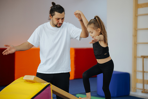 Cute active child girl in sensory integration room, kindergarten. Kid is active leisure. Childhood and sporty lifestyle.Sports weekend in gymnastic center. Fitness,healthy, develop skills concept